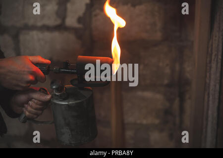 Old rusty chalumeau avec le feu dans les mains des hommes Banque D'Images