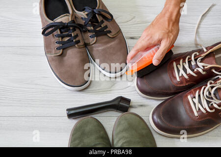 L'homme le nettoyage et le polissage de souliers en cuir avec pinceau sur fond de bois Banque D'Images