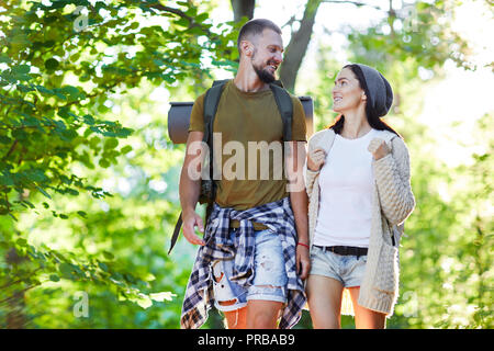 Couple de randonneurs la conversation tout en allant dans la forêt sur journée d'été Banque D'Images