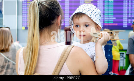 Portrait of young woman holding et son petit garçon en attente de l'aéroport en vol Banque D'Images