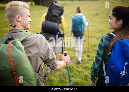 Groupe d'amis sont la randonnée en montagne. Les jeunes gens marchant à travers la campagne. Banque D'Images