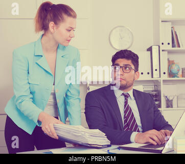 Office worker choqués par l'énorme pile de documents traduits par son patron Banque D'Images