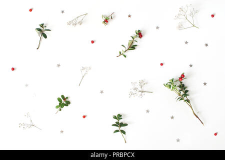 Motif floral de Noël. Composition de l'hiver, branches de canneberges rouges gypsophile fleurs et confettis argent étoile sur le tableau blanc. Arrière-plan de fête. Mise à plat, vue du dessus. Banque D'Images
