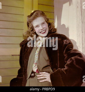 1950s mode. Une jeune femme souriante porte un faux manteau de fourrure à l'extérieur de la robe à deux pièces. Suède 1958. Réf. BV88-3 Banque D'Images