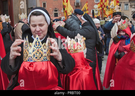 Nun aider les enfants avec leurs couronnes devant papier Cavalcade des Rois Mages, Epiphany Maison de procession, Cracovie, Pologne Banque D'Images