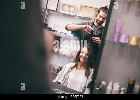 Young woman getting nouvelle coiffure coiffure professionnel au saloon. Banque D'Images