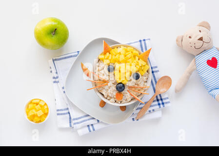 Le petit-déjeuner pour les enfants, les enfants d'avoine farine de gruau à décor à l'aide de fruits et de baies aussi mignon drôle fox et ours sur le côté. L'art de l'alimentation Banque D'Images