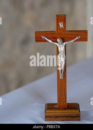 Crucifix en bois sur fond de tissu blanc autel. La foi chrétienne. Banque D'Images