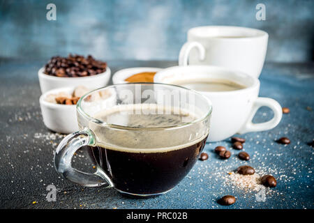 Trois tasses à café, des haricots, du café moulu et le sucre brun. Fond bleu foncé Vue de dessus de l'espace pour votre texte Banque D'Images