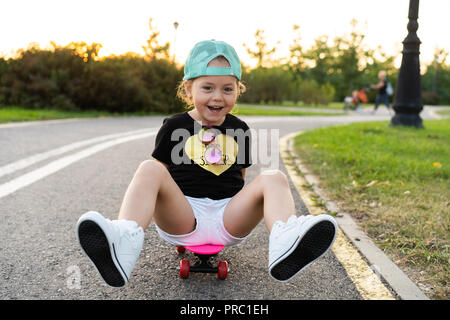 Child riding skateboard park en été. Petite fille à apprendre à faire du vélo skate board. Sport actif à l'extérieur pour l'école et le jardin d'enfants. Enfants planche à roulettes. Bambin sur longboard. Patinage artistique pour enfants Banque D'Images