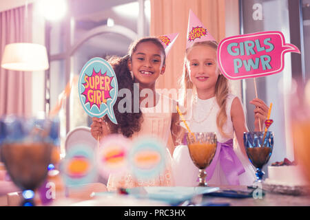 Deux amis appréciant kids party et drôle holding signs Banque D'Images