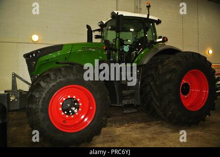 Image composite d'un tracteur générique agricole vert moderne avec des roues rouges, à l'intérieur sur un fond blanc Banque D'Images