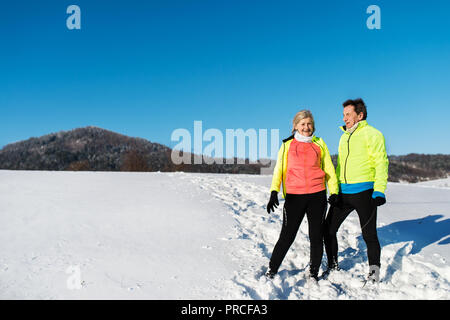 Senior couple porteur debout dans la nature, le repos d'hiver. Copier l'espace. Banque D'Images