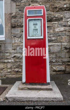 Rouge à l'ancienne pompe à essence sur la rue dans un village irlandais. Banque D'Images