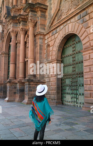 Femme debout devant la magnifique porte de la cathédrale de Cusco, Cusco, Pérou, Amérique du Sud Banque D'Images