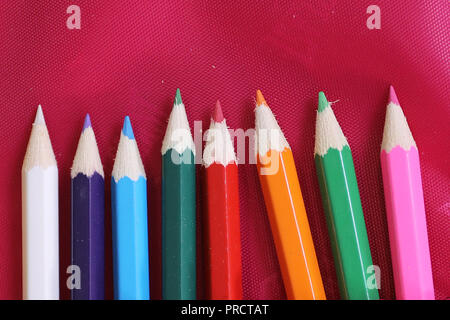 Crayons de couleur tourné sur un fond rouge Banque D'Images