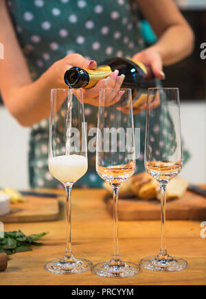 Woman pouring champagne en verre avec des bulles. Close up Banque D'Images