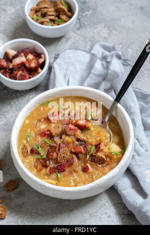 Garnir la soupe aux pois, lentilles aux lardons et croûtons Banque D'Images