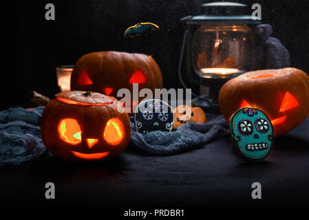 Les citrouilles avec des bougies et du crâne de cookies, halloween theme fond sombre. Banque D'Images