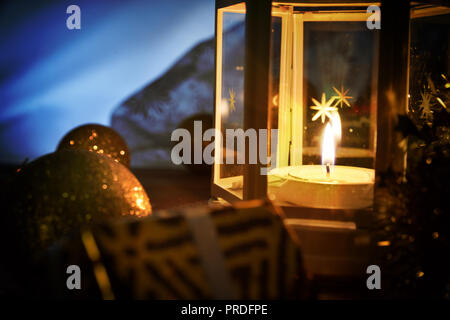 Composition avec lanterne allumée et décoration de Noël sur la table en bois dans l'obscurité. Composition horizontale Banque D'Images