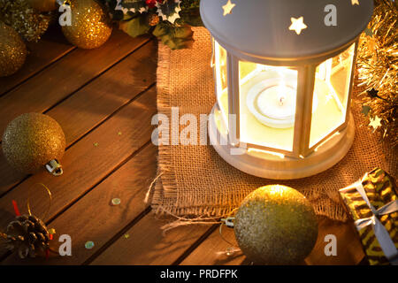Composition avec lanterne allumée et décoration de Noël sur la table en bois dans l'obscurité. Composition horizontale. Vue élevée. Banque D'Images