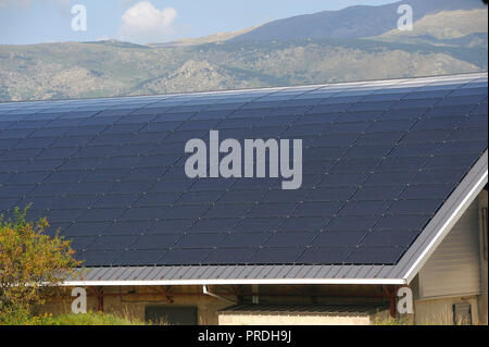 Toit solaire d'une grande surface courbe sur un édifice municipal d'un petit village dans les Pyrénées Banque D'Images