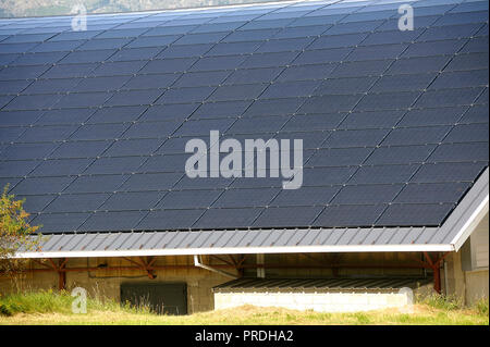 Toit solaire d'une grande surface courbe sur un édifice municipal d'un petit village dans les Pyrénées Banque D'Images