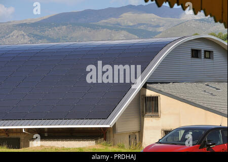 Toit solaire d'une grande surface courbe sur un édifice municipal d'un petit village dans les Pyrénées Banque D'Images