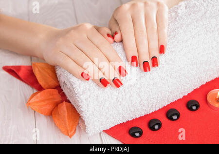 Manucure rouge avec dekor et serviettes sur la table en bois blanc. Essentiel Spa. Banque D'Images