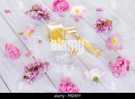 Flacons de parfum de fleurs sur fond blanc Banque D'Images