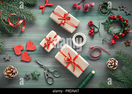 Fond en bois rustique en vert et rouge avec des branches de sapin de Noël et cadeaux, décorations de Noël Banque D'Images