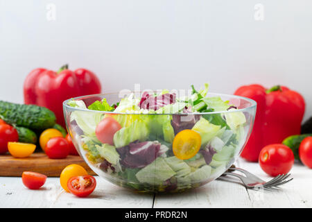 Bol plein de salade verte fraîche close up sur une table lumineuse sur un fond blanc sur une cuisine rustique. Concept utile et simple de la nourriture. Banque D'Images