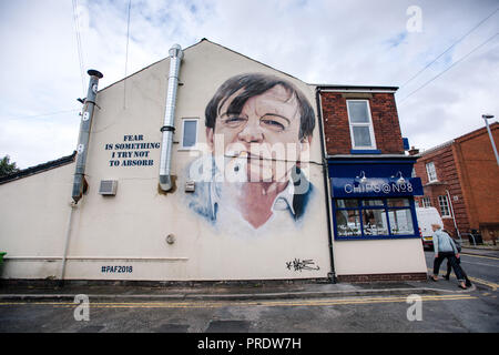 Prestwich, Royaume-Uni. 1er octobre 2018. L'artiste Graffiti Akse p19 termine son portrait du leader de l'automne Mark E.Smith sur le côté d'une boutique de jetons de Manchester. Le chanteur de la chute, décédé en janvier 2018, est commémoré dans sa ville natale de Prestwich, dans le Grand Manchester, pour un festival des arts. Crédit : Howard Harrison/Alay Live News Banque D'Images