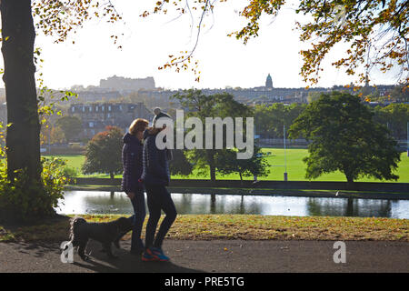 Édimbourg, Inverleith Park, Ecosse, Royaume-Uni. 2e oct, 2018. Météo, ensoleillée, avec 11 degrés et 19 km/h avec des rafales de vents de 28 km/h du nord, les gens de terminer contre le froid tout en marchant dans le parc, les couleurs d'automne sont arrivés plus tôt que d'habitude mais laisse soufflent au large des branches en raison des vents de tempête. Banque D'Images