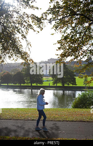 Édimbourg, Inverleith Park, Ecosse, Royaume-Uni. 2e oct, 2018. Météo, ensoleillée, avec 11 degrés et 19 km/h avec des rafales de vents de 28 km/h du nord, les gens de terminer contre le froid tout en marchant dans le parc, les couleurs d'automne sont arrivés plus tôt que d'habitude mais laisse soufflent au large des branches en raison des vents de tempête. Banque D'Images