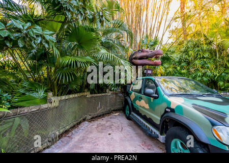 ORLANDO, FLORIDE, USA - DÉCEMBRE, 2017 : entre les buissons de dinosaures avec sa bouche ouverte montrant ses dents sur une voiture dans le parc à thème Universal Studios O Banque D'Images