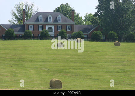 Balles de foin sur le terrain devant une grande maison dans la campagne de Virginie, aux États-Unis Banque D'Images