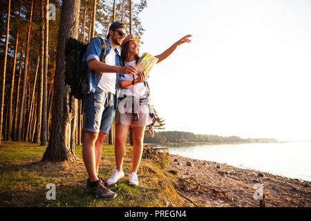 Couple heureux de partir en randonnée ensemble dans une forêt. Banque D'Images