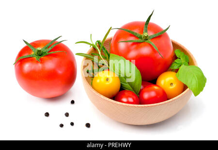 De délicieuses tomates fraîches et fines herbes dans un bol en bois. Close up shot, isolé sur fond blanc. La gastronomie ou l'alimentation saine. Banque D'Images