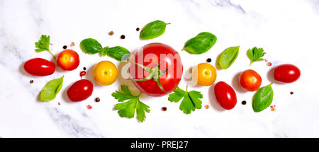 De délicieuses tomates fraîches sur un fond noir en marbre blanc. Vue de dessus avec l'exemplaire de l'espace. Banque D'Images