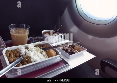 Ensemble de repas à bord d'une case, sur la table pliante en classe économique. Les passagers d'alimentation d'aliments asiatiques dans l'avion au Kazakhstan. Le voyage tou Banque D'Images