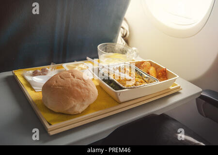 Partie de la nourriture pour un seul passager à bord de l'avion. Sur un plat indien table pliante à bord de l'avion dans l'avion en classe économique. l Banque D'Images