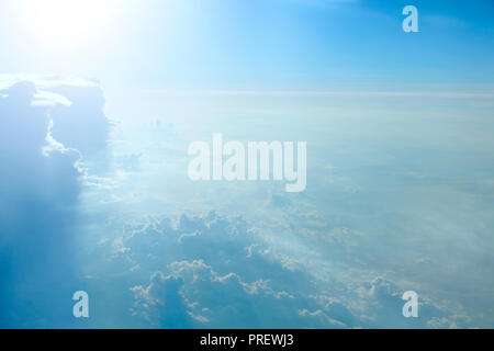 Très belle vue depuis la fenêtre de l'avion dans le soleil du matin sur les nuages. Nuages inhabituels éclairée par des rayons de soleil. Les nuages blancs sur fond de ciel bleu. Blazin Banque D'Images
