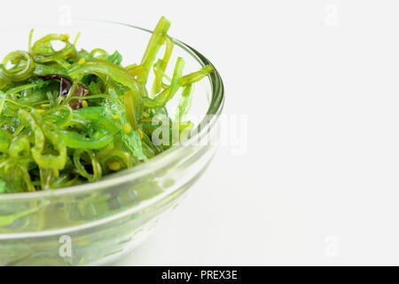Salade de wakamé au sésame dans un petit bol en verre isolé sur fond blanc Banque D'Images