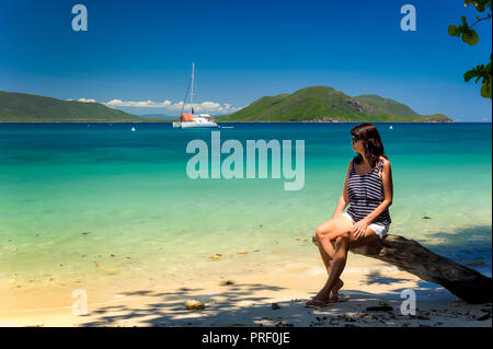 Le tourisme repose sur une plage dans les eaux cristallines de l'île de Fitzroy en Far North Queensland tropical. Banque D'Images