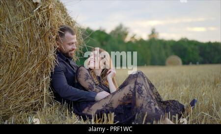 Histoire d'amour d'un jeune couple dans la nature. Le mec embrasse la jeune fille qui ferma les yeux et jouit de l'instant Banque D'Images