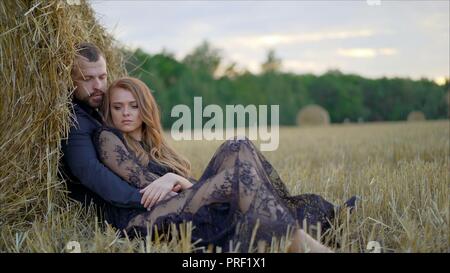 Histoire d'amour d'un jeune couple dans la nature. Le mec embrasse la jeune fille qui ferma les yeux et jouit de l'instant Banque D'Images