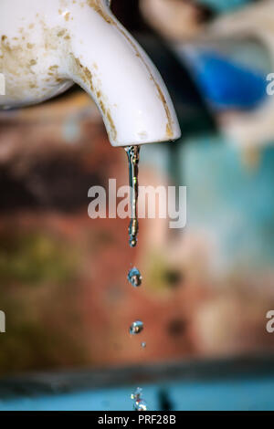 Fuite d'eau douce de l'ancien tuyau de plastique. Close up. Isolé de l'arrière-plan. La conservation de l'eau ménage Concept. Banque D'Images
