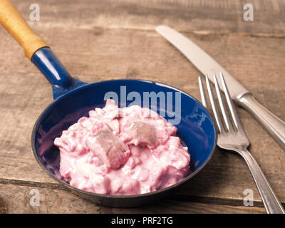 Hareng savoureux avec racine de betterave sauce dans une poêle de fer sur une table en bois Banque D'Images