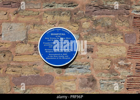 Plaque sur le mur de l'hôpital de la Sainte Trinité, la Vierge Marie et saint Jean le Baptiste sur Broad Street à côté de ludford Bridge, Ludlow, Shropshire, Angleterre Banque D'Images